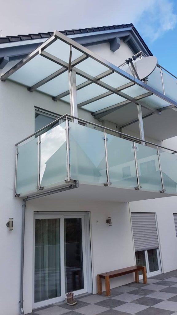 Glasdach als Balkonüberdachung über einem Balkon mit Glasgeländer