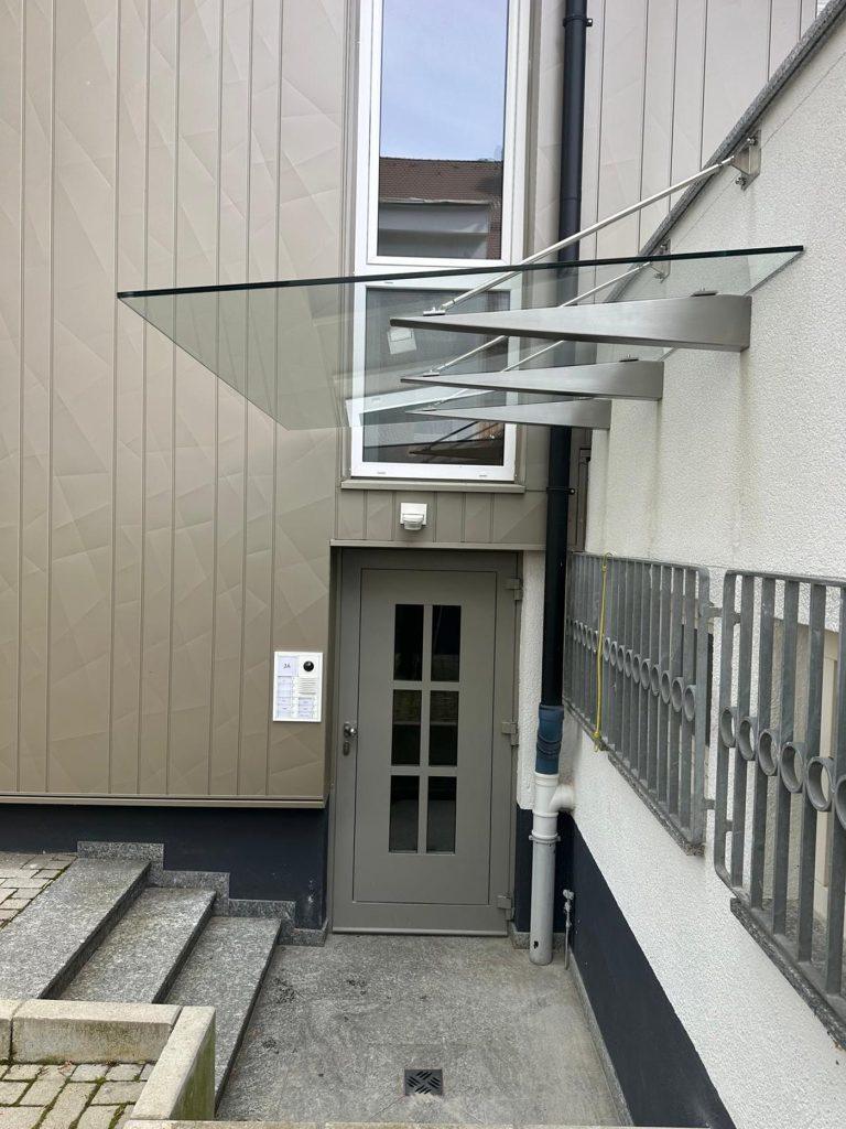 Dreieckiges Glasvordach über einer Hauseingangstür